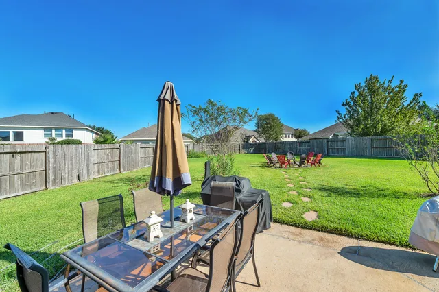 a view of a chairs and table in patio with a yard