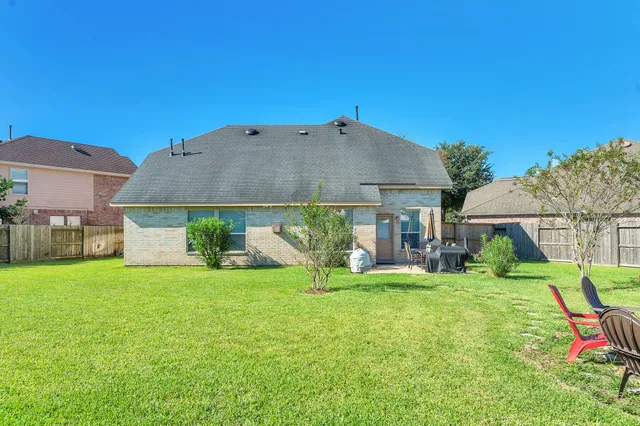 a view of a house with backyard and sitting area