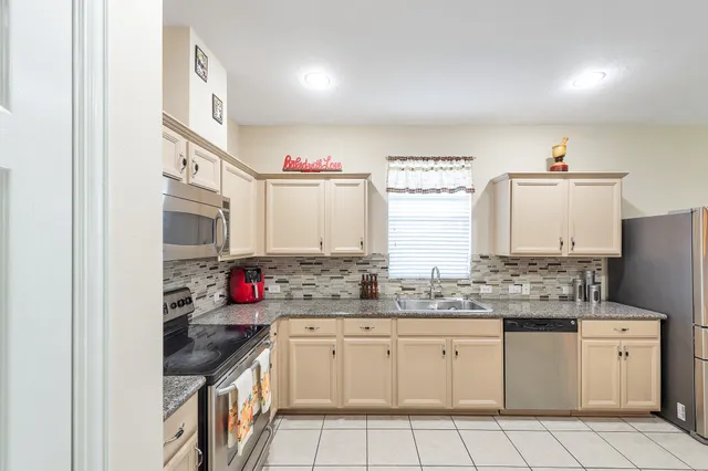 a kitchen with stainless steel appliances granite countertop a sink stove and cabinets