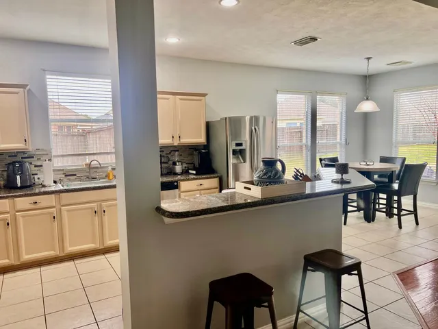 a kitchen with stainless steel appliances kitchen island granite countertop a sink and cabinets