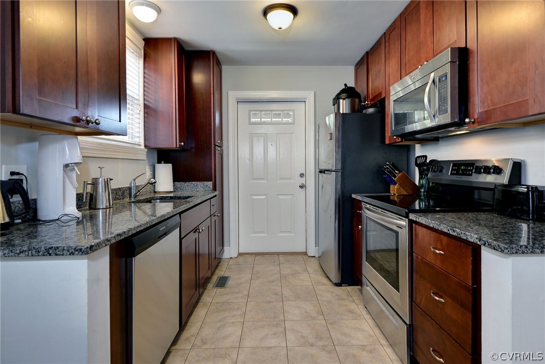 905 Lake Road Richmond, VA 23220 - Photo 14 of 50 a kitchen with stainless steel appliances granite countertop a sink and dishwasher a stove top oven with wooden floor
