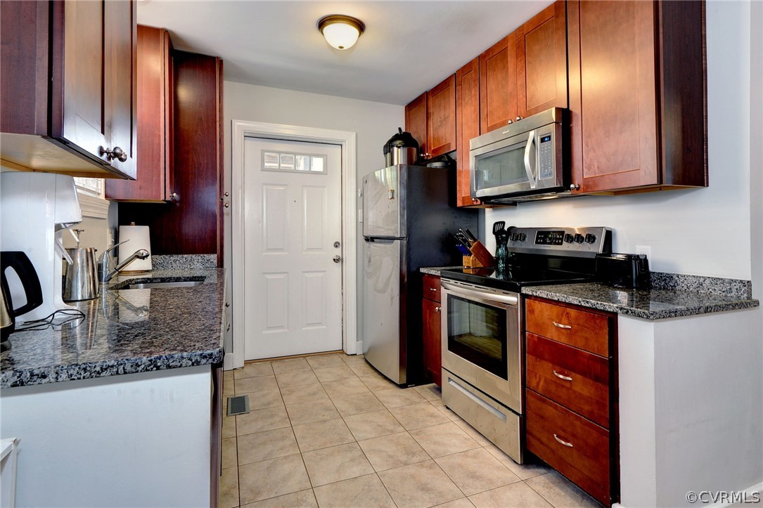 905 Lake Road Richmond, VA 23220 - Photo 15 of 50 a kitchen with stainless steel appliances granite countertop a stove a sink and a microwave