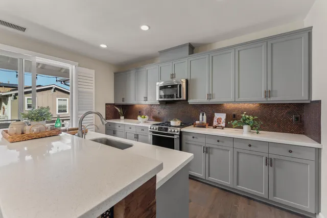 a kitchen with sink a stove and cabinets