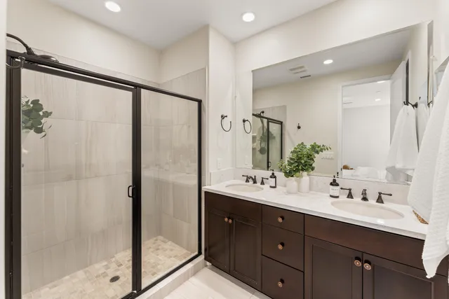 a bathroom with a double vanity sink mirror double and shower