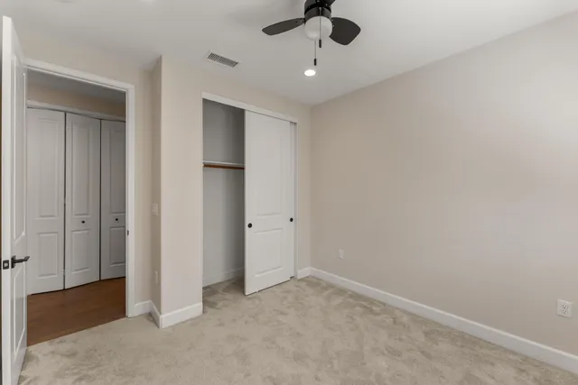 an empty room with a window and a ceiling fan