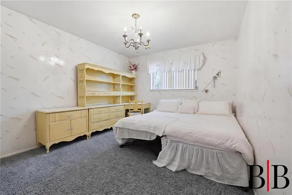 a spacious bedroom with a bed and a chandelier