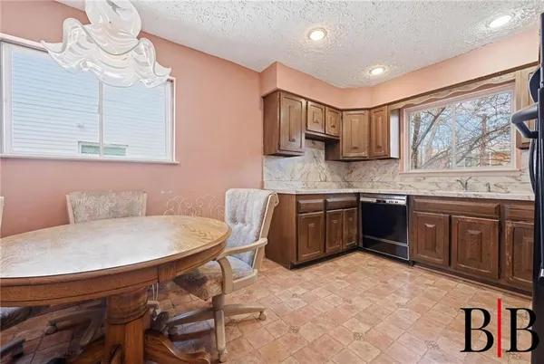 a kitchen with a stove a sink a dining table and chairs
