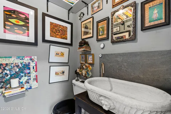 a bathroom with a bathtub and a painting on the wall