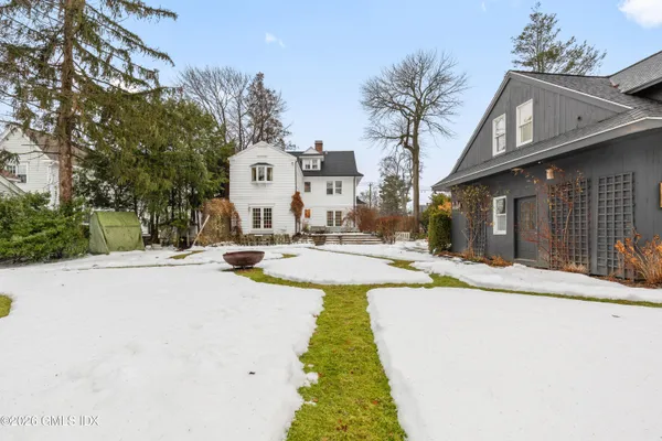 a view of a white house with a large trees