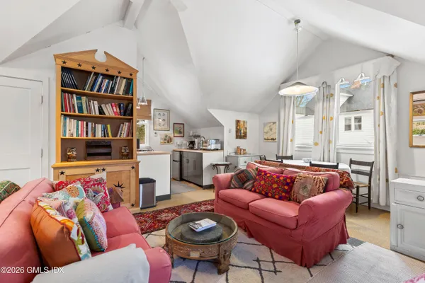 a living room with furniture a rug and a book shelf