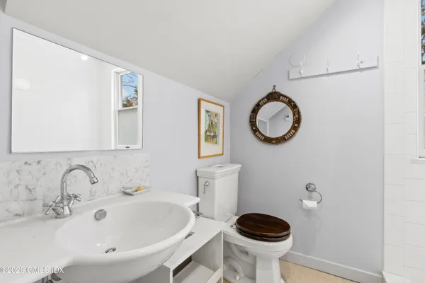 a bathroom with a toilet a sink and mirror