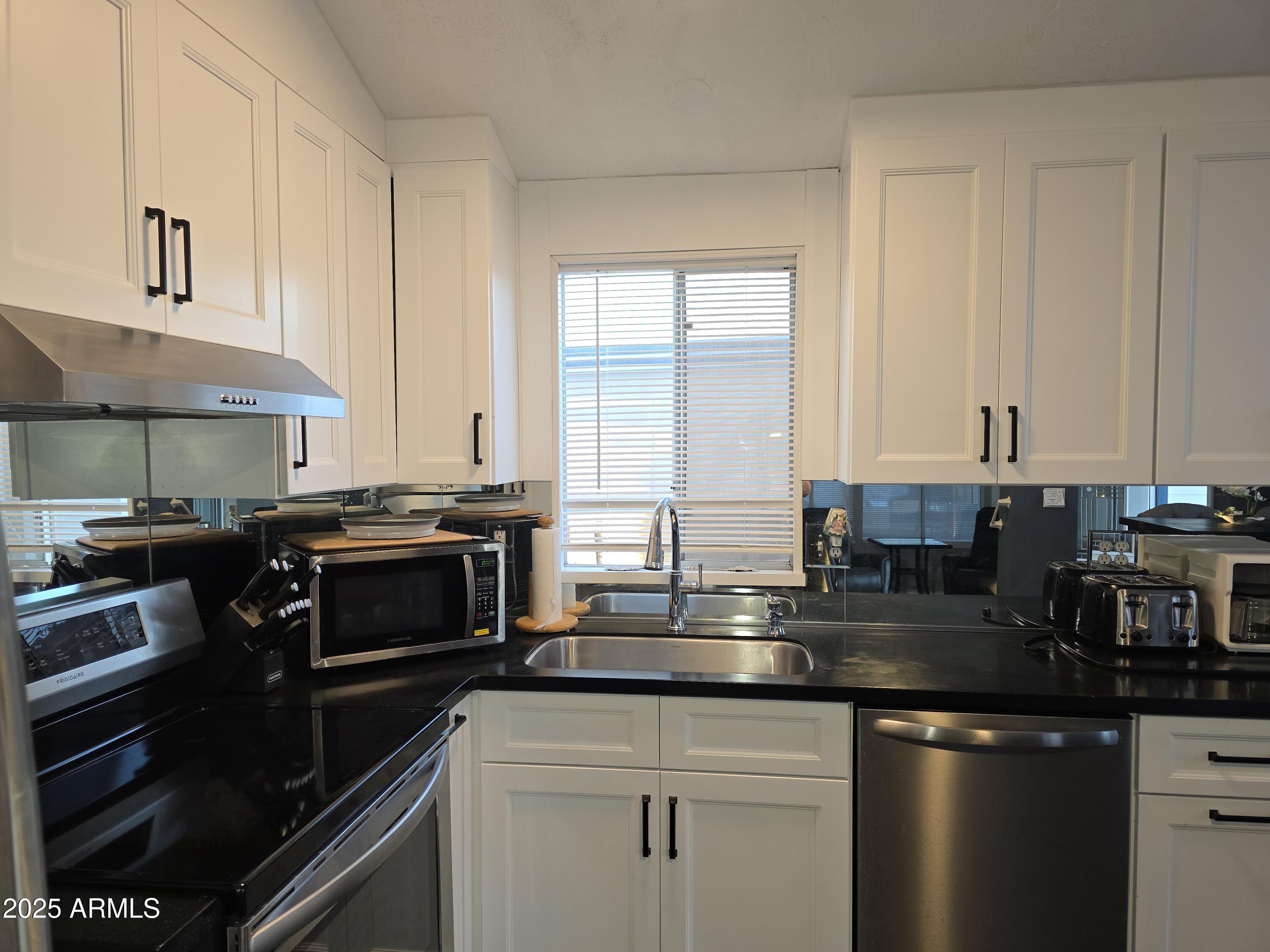 2090 South Cherokee Drive Apache Junction, AZ 85119 - Photo 3 of 11 a kitchen with stainless steel appliances granite countertop a stove a sink and a microwave