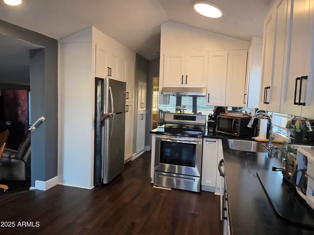 a kitchen with stainless steel appliances a refrigerator a stove a sink and a stove