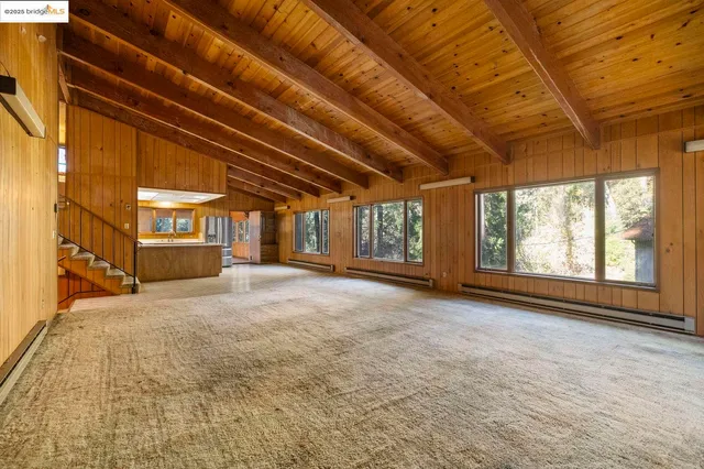 a view of an empty room with a fireplace and a window