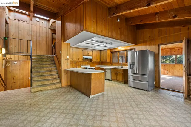 a kitchen with stainless steel appliances kitchen island granite countertop a refrigerator and a stove