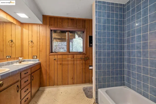 a bathroom with a tub a sink and mirror