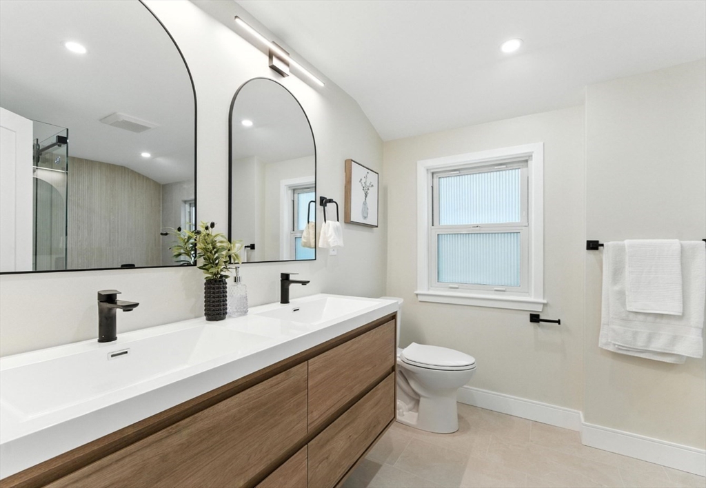 76 Orchard Street, Unit 76 Medford, MA 02155 - Photo 16 of 21 a bathroom with a double vanity sink toilet and a mirror