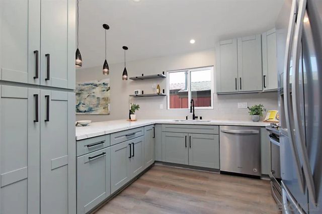 a kitchen with stainless steel appliances a refrigerator stove and sink