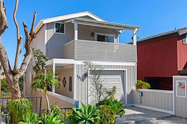 a front view of a house with plants