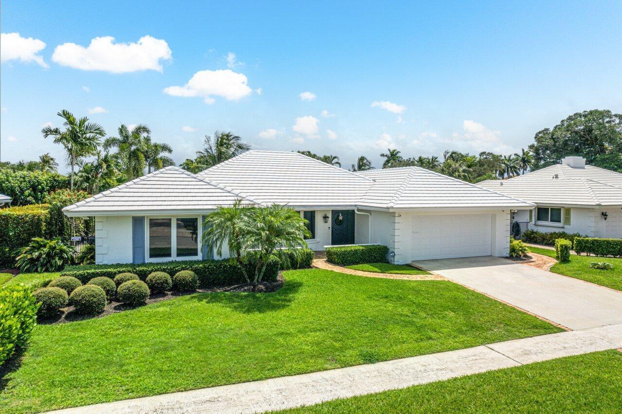 670 Elm Tree Lane Boca Raton, FL 33486 - Photo 1 of 44 a front view of a house with a garden and patio