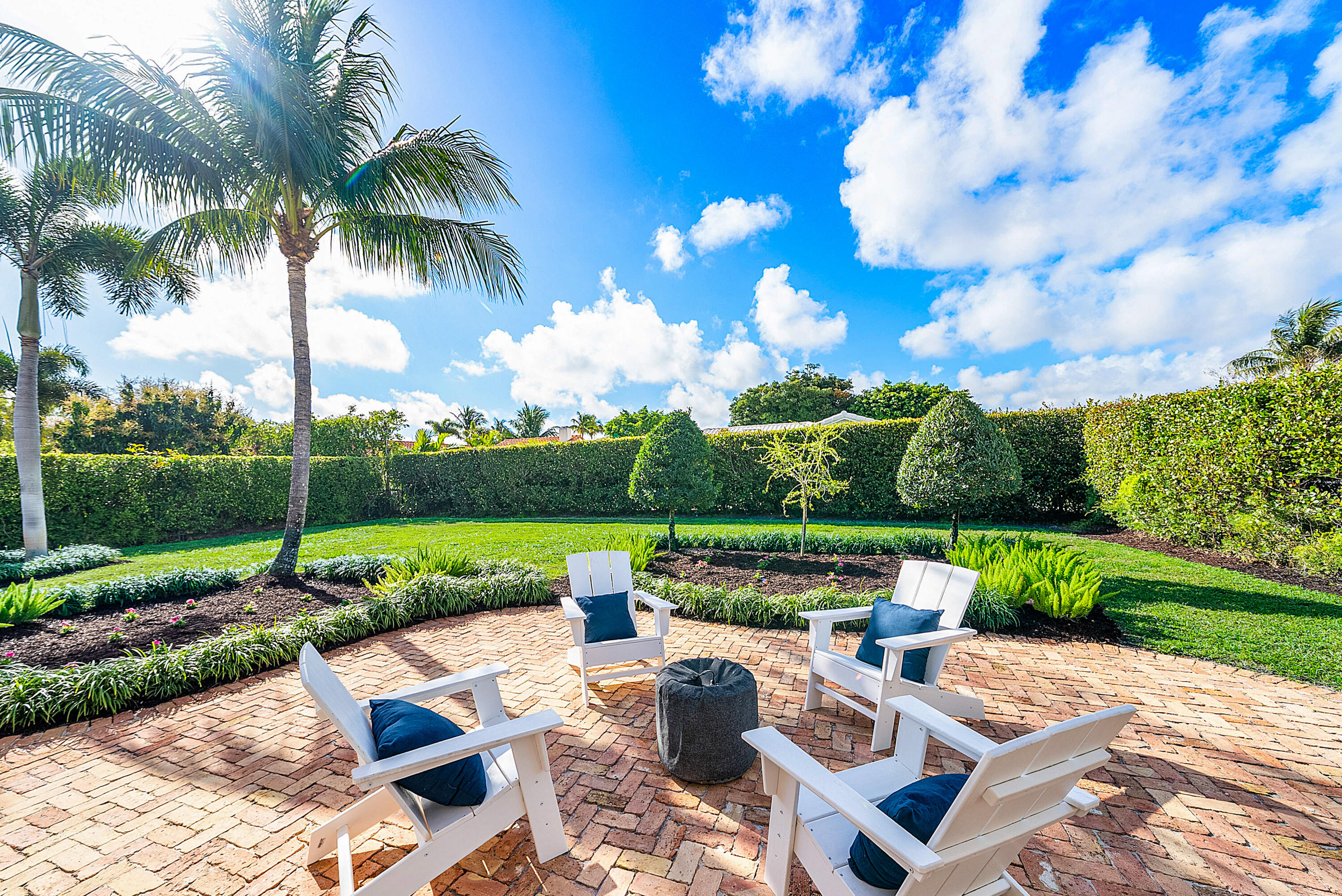 670 Elm Tree Lane Boca Raton, FL 33486 - Photo 12 of 44 a view of a patio with couches chairs under an umbrella