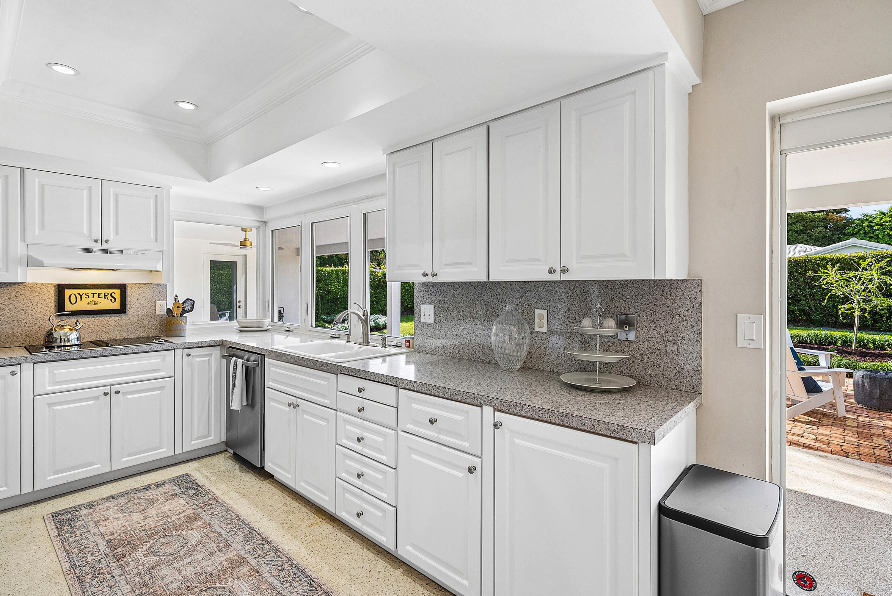670 Elm Tree Lane Boca Raton, FL 33486 - Photo 21 of 44 a kitchen with granite countertop white cabinets and white appliances