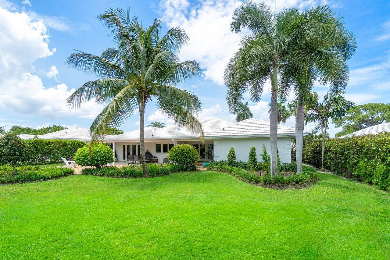 670 Elm Tree Lane Boca Raton, FL 33486 - Photo 34 of 44 a view of a house with a yard and palm trees