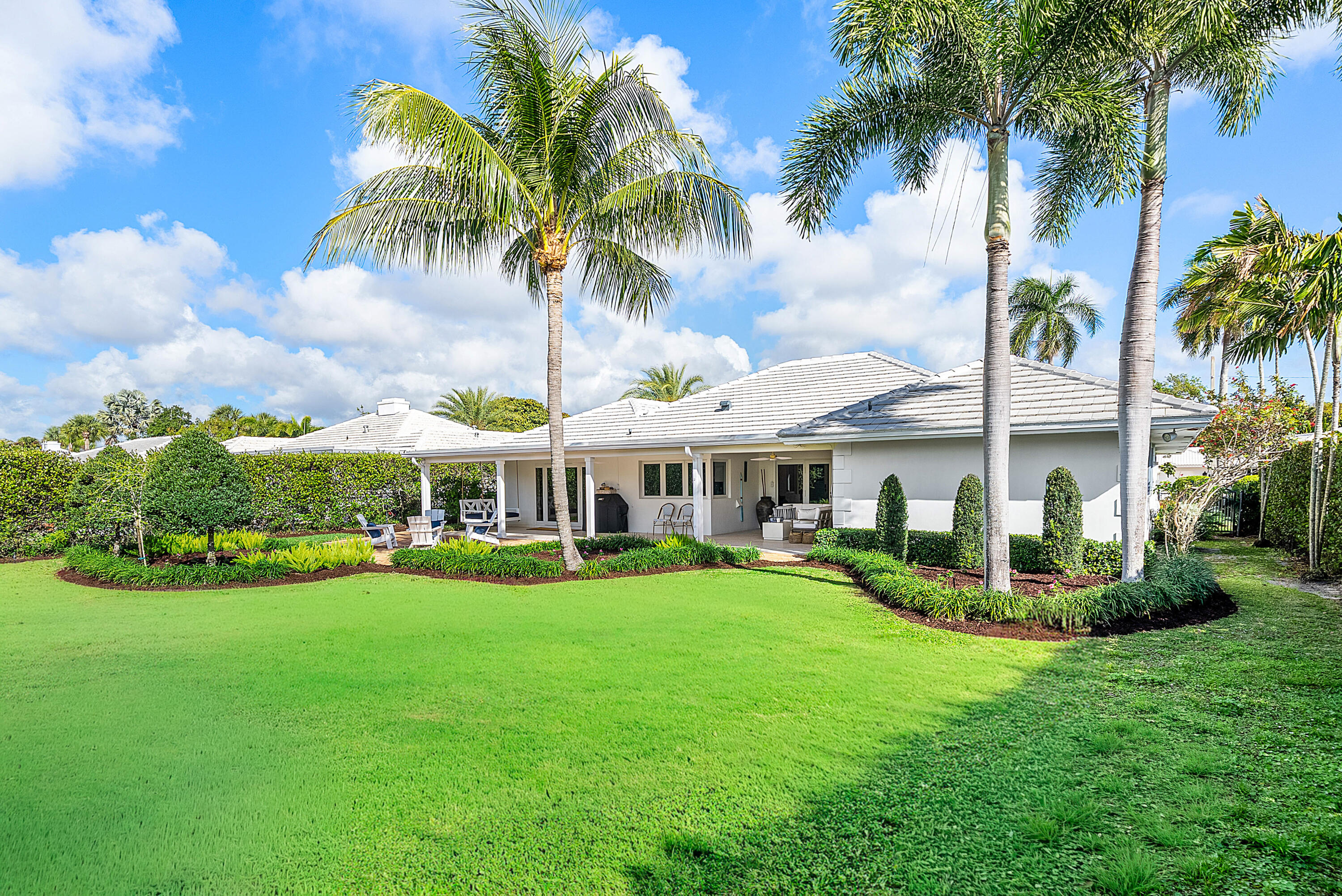 670 Elm Tree Lane Boca Raton, FL 33486 - Photo 8 of 44 a front view of a house with a garden and trees