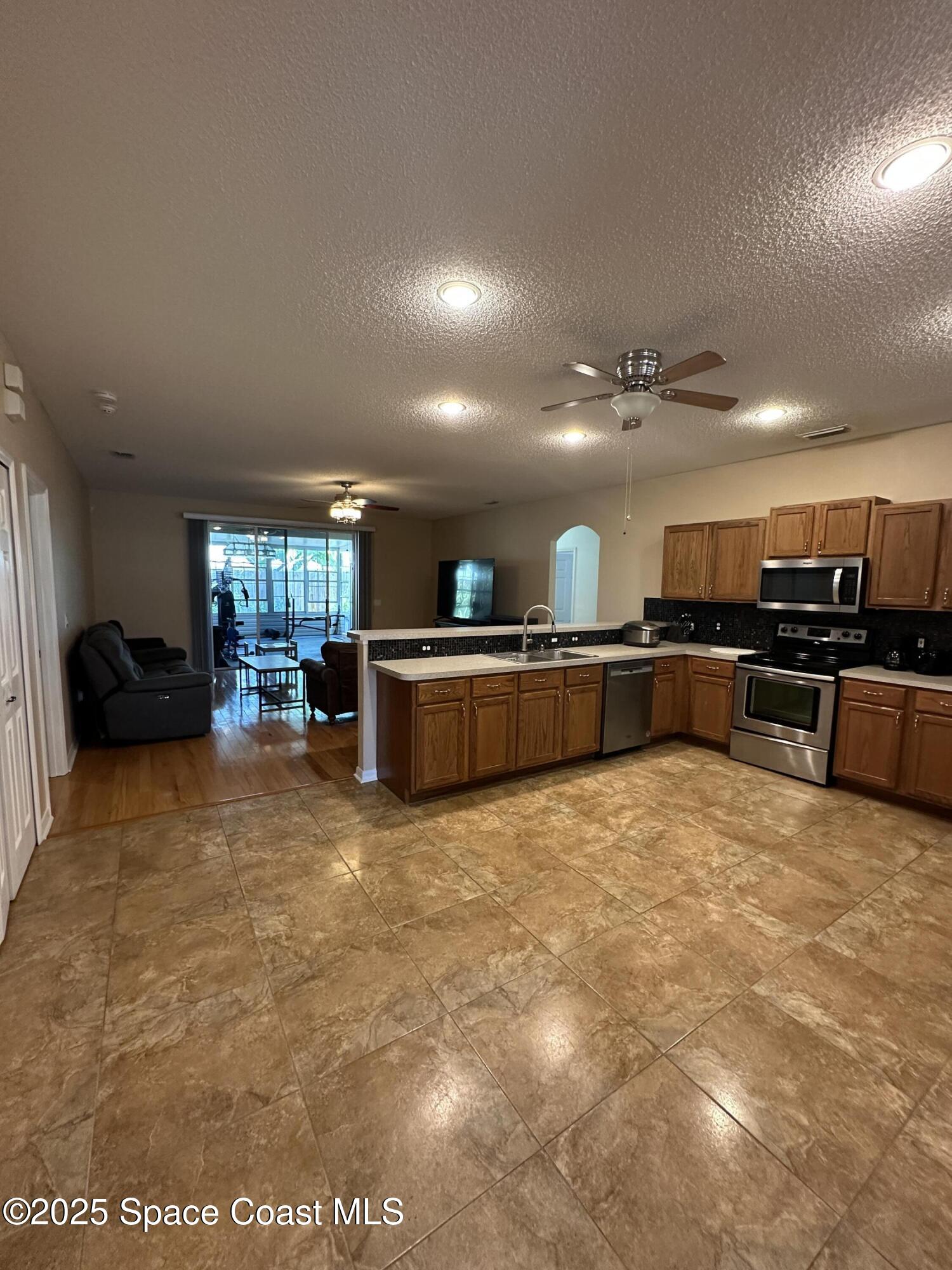 1354 Enclave Drive Rockledge, FL 32955 - Photo 2 of 27 a large kitchen with stainless steel appliances granite countertop a large counter top and a stove