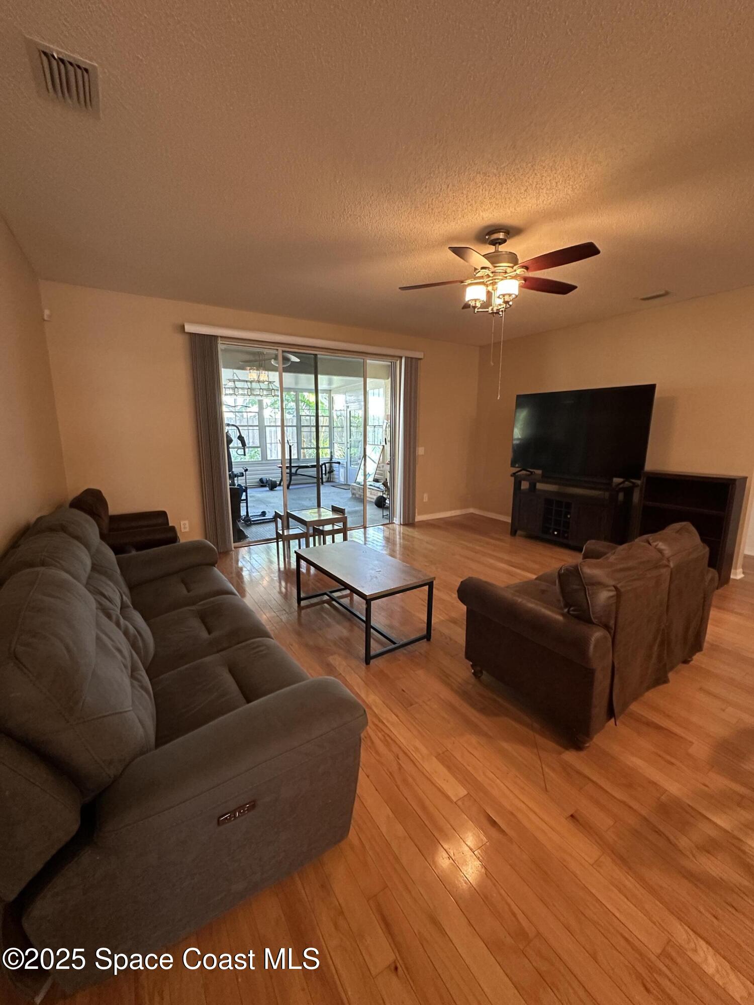 1354 Enclave Drive Rockledge, FL 32955 - Photo 7 of 27 a living room with furniture a ceiling fan and a window