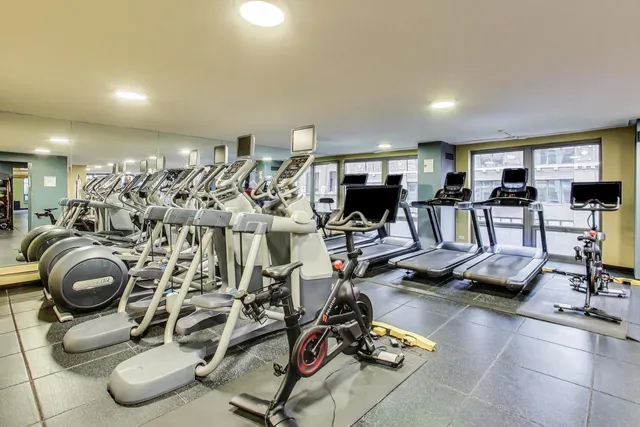 a living room with furniture gym equipment and a large window