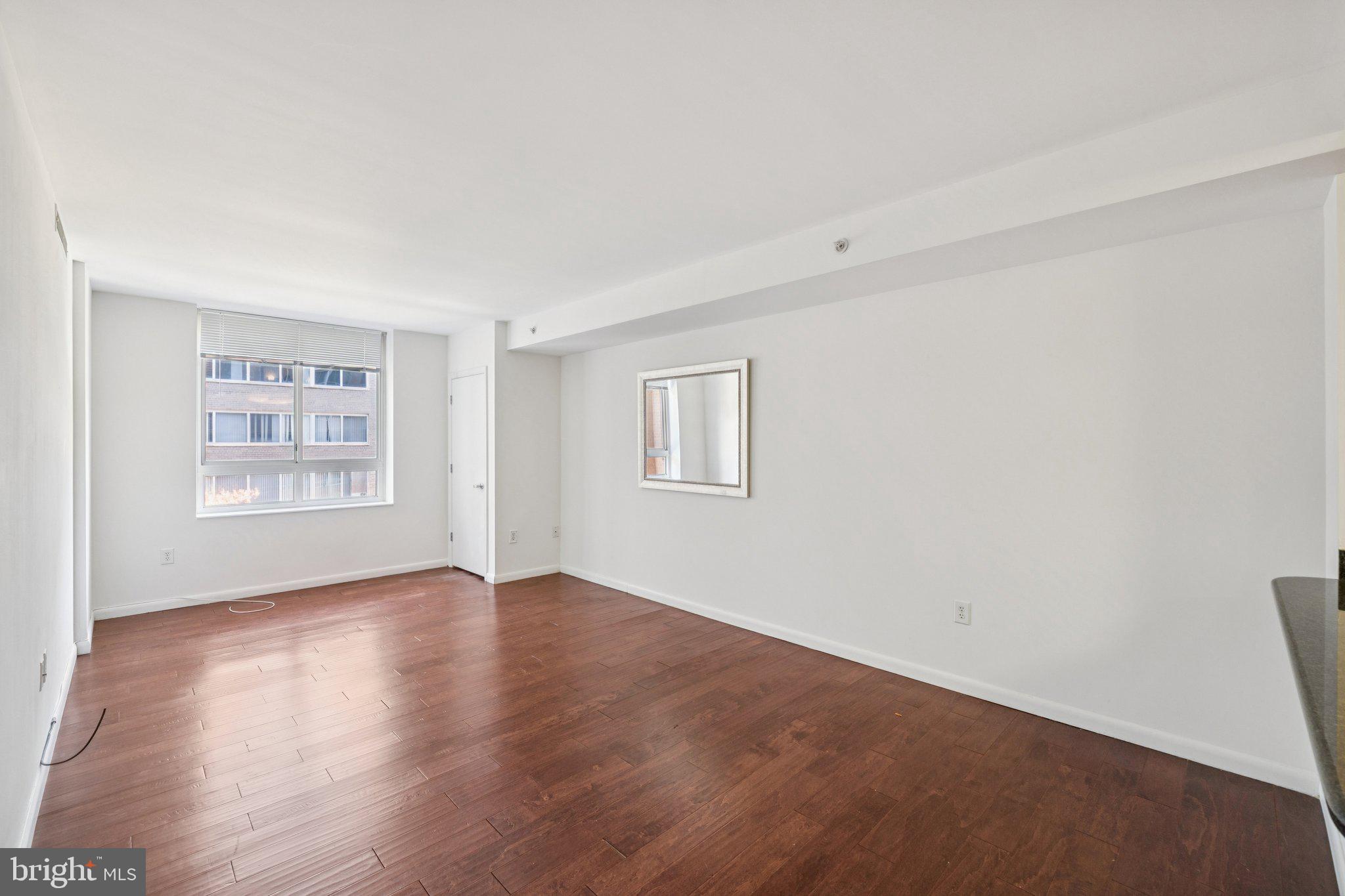 355 I Street Southwest, Unit 410 Washington, DC 20024 - Photo 11 of 31 an empty room with wooden floor and windows