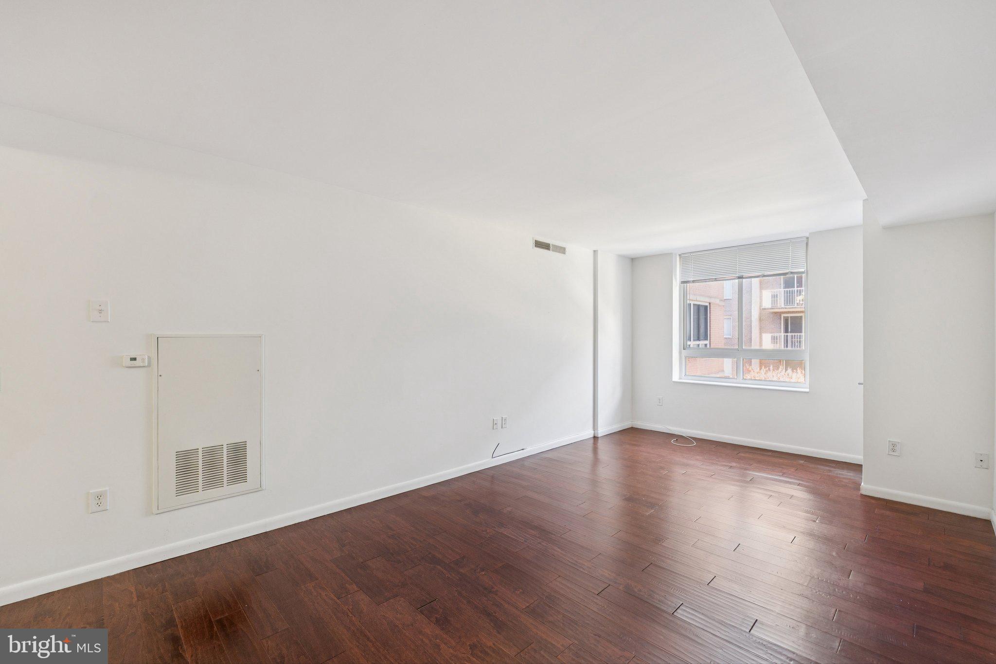 355 I Street Southwest, Unit 410 Washington, DC 20024 - Photo 13 of 31 a view of an empty room with wooden floor and a window