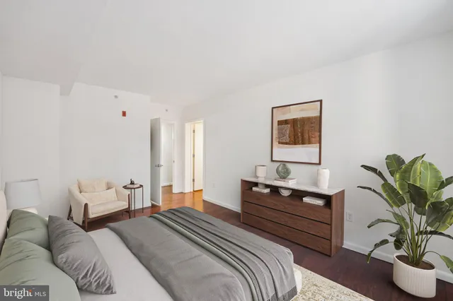 a bedroom with a bed and a potted plant