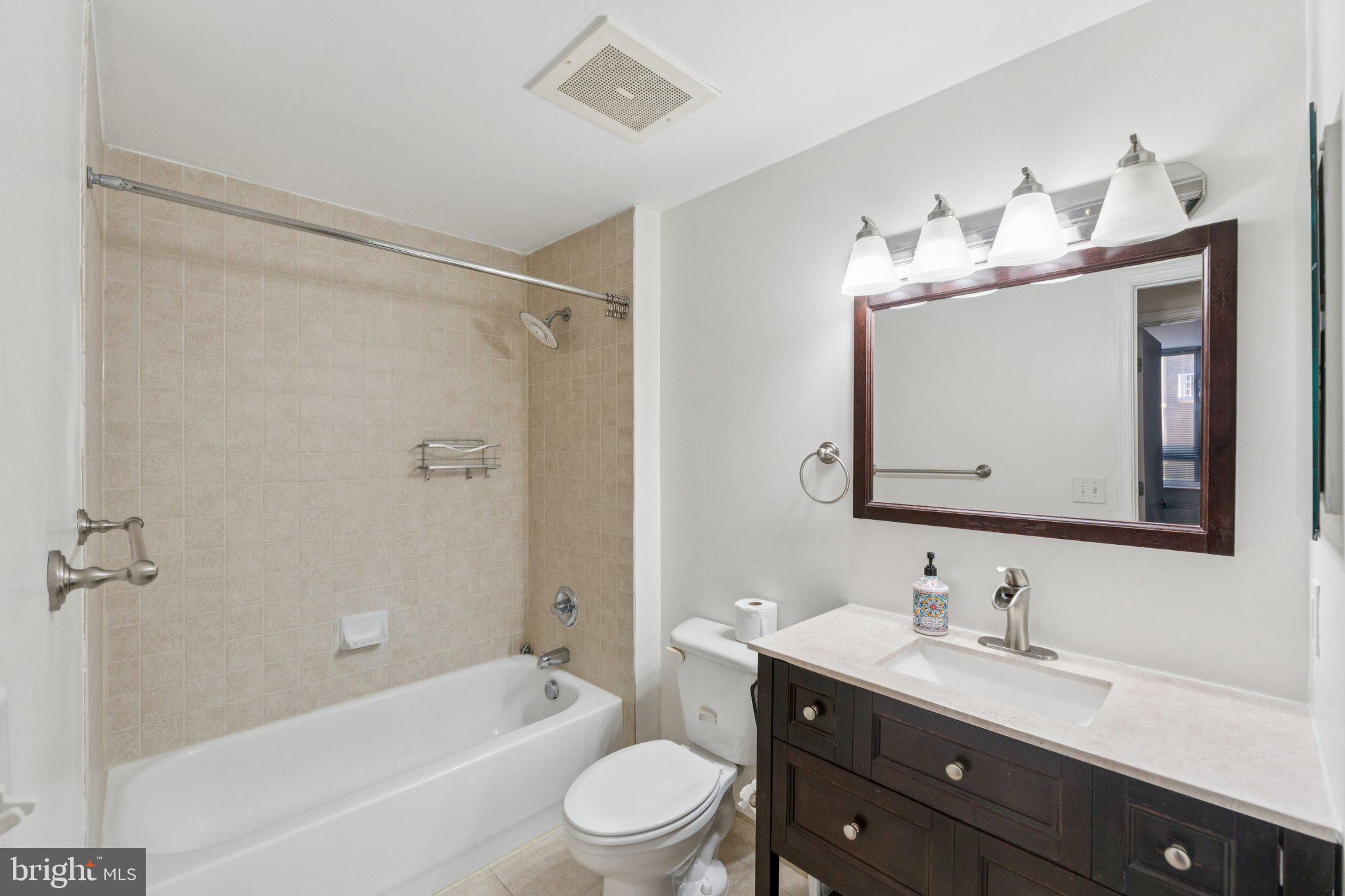 355 I Street Southwest, Unit 410 Washington, DC 20024 - Photo 24 of 31 a bathroom with a toilet a sink a tub a mirror and vanity