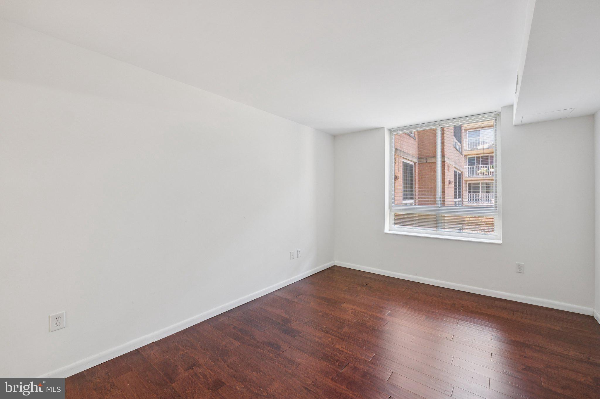 355 I Street Southwest, Unit 410 Washington, DC 20024 - Photo 27 of 31 an empty room with wooden floor and windows
