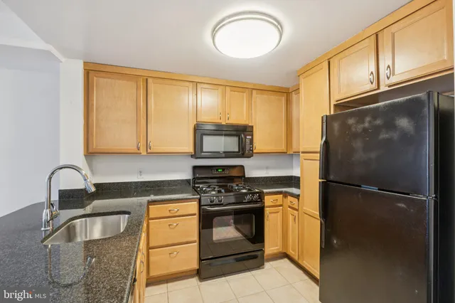 a kitchen with a refrigerator sink and cabinets