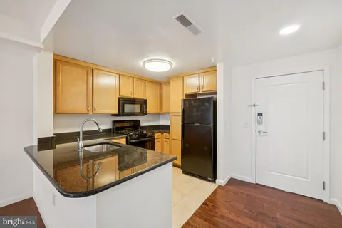 a kitchen with granite countertop a sink stove and refrigerator