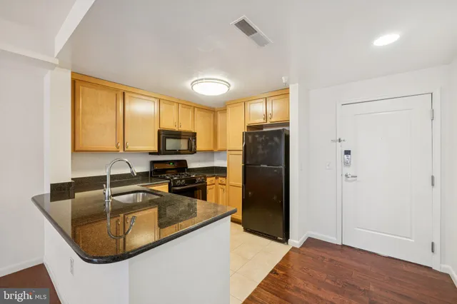 a kitchen with granite countertop a sink stove and refrigerator