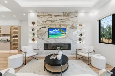 a living room with furniture a flat screen tv and a large window