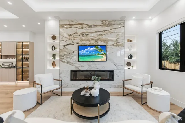 a living room with furniture a flat screen tv and a large window