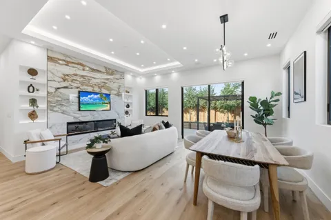 a living room with furniture kitchen view and a flat screen tv