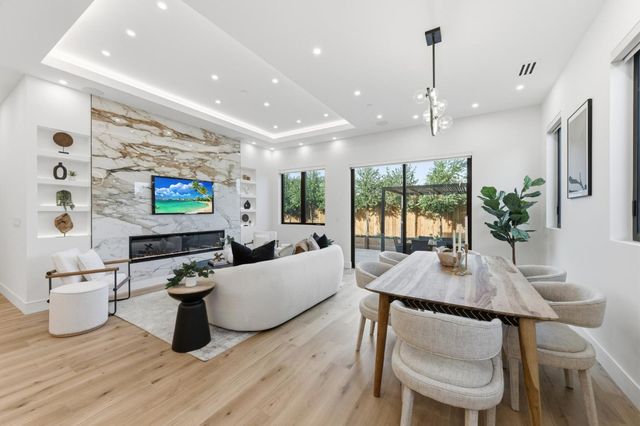 a living room with furniture kitchen view and a flat screen tv