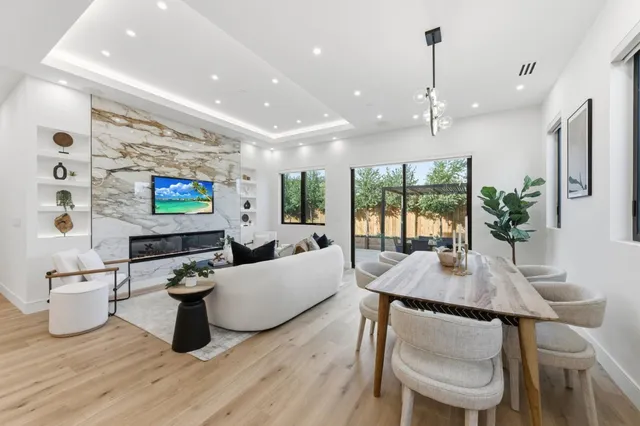 a living room with furniture kitchen view and a flat screen tv