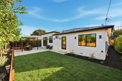 a view of a house with backyard and sitting area