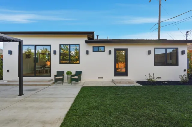 a large kitchen with stainless steel appliances kitchen island a large counter top a sink and a wooden floor