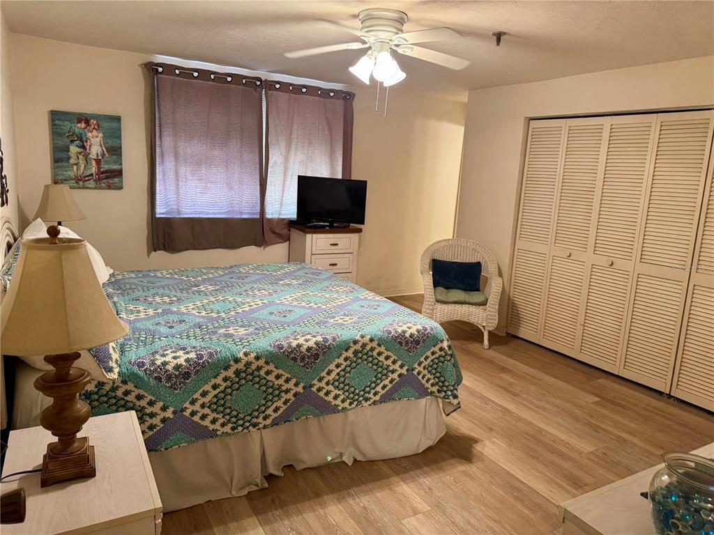 16330 Gulf Boulevard, Unit 201 Redington Beach, FL 33708 - Photo 5 of 30 a bedroom with a bed and a flat tv screen on dresser