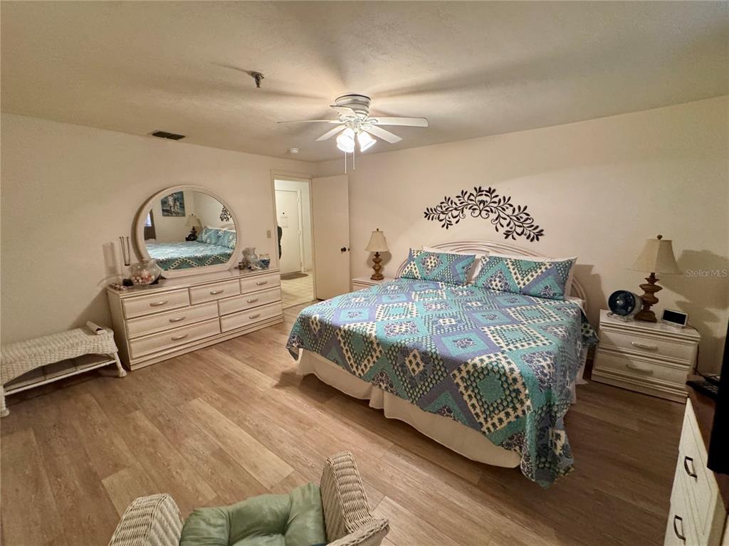 16330 Gulf Boulevard, Unit 201 Redington Beach, FL 33708 - Photo 6 of 30 a bedroom with a bed and a chandelier
