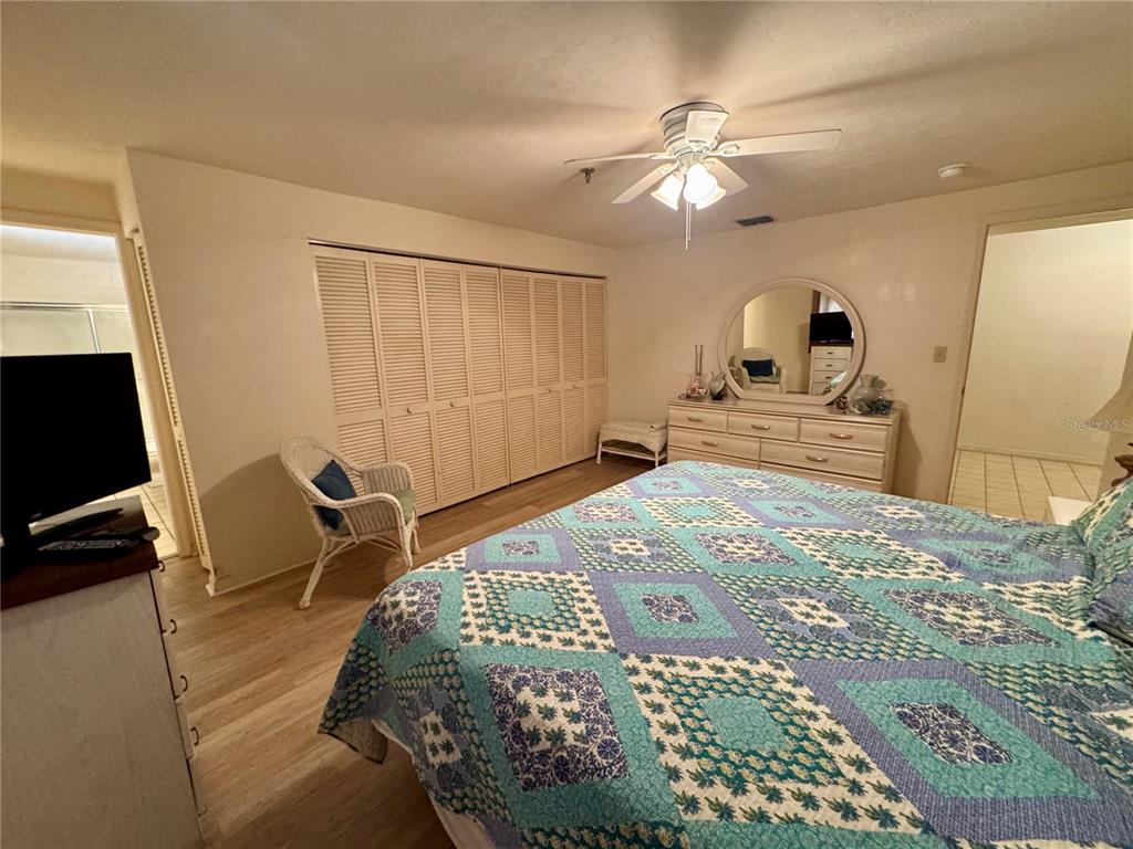 16330 Gulf Boulevard, Unit 201 Redington Beach, FL 33708 - Photo 7 of 30 a bedroom with a bed and a chandelier