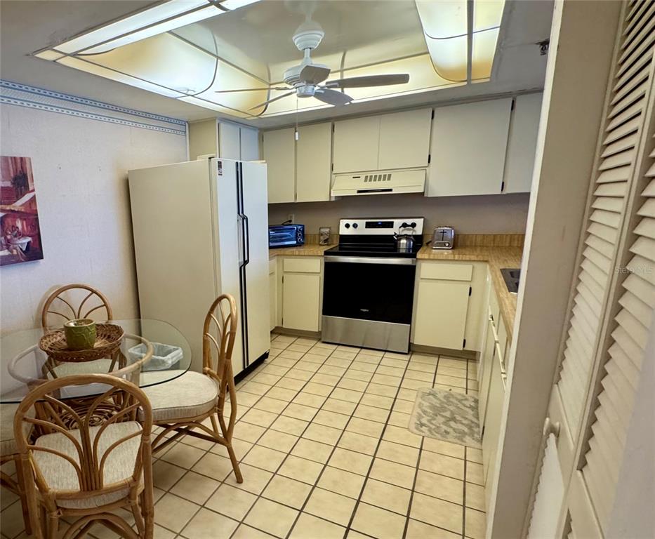 16330 Gulf Boulevard, Unit 201 Redington Beach, FL 33708 - Photo 10 of 30 a kitchen with stainless steel appliances granite countertop a stove a refrigerator and a microwave